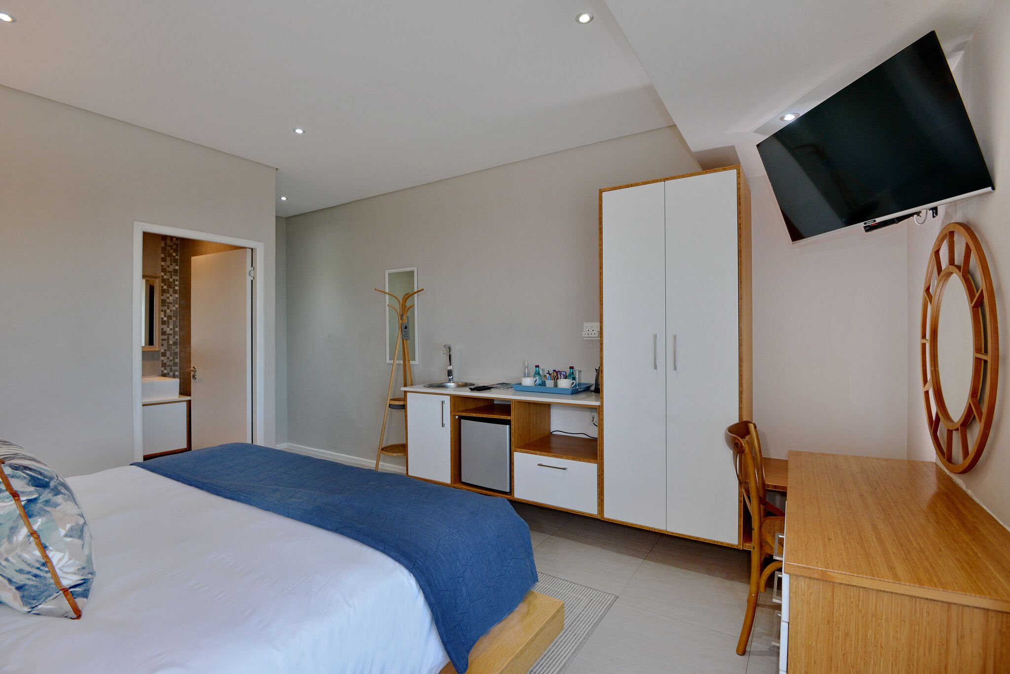 Une chambre à coucher comprenant un lit, un bureau, une chaise, un téléviseur et une armoire.