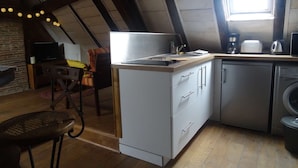 A compact kitchen with a wooden countertop, a built-in dishwasher, and a window providing natural light. - Charming studio "Le Colombier" - Habitation Saint-Clar Historic Center - WIFI / Netflix (Bergerac)