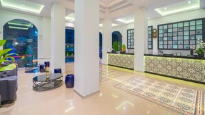 A hotel lobby with a reception desk, seating area, and decorative elements. - Vapa Hotel (Phuket)