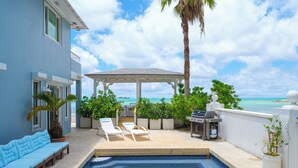A pool area with lounge chairs, a barbecue grill, and a view of the ocean. - LUXURY HOUSE WITH PRIVATE BEACH (Nassau)