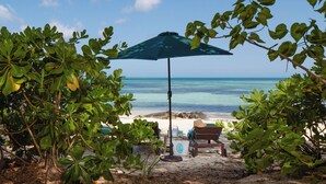 A beach view with a wooden bench and an umbrella. - LUXURY HOUSE WITH PRIVATE BEACH (Nassau)