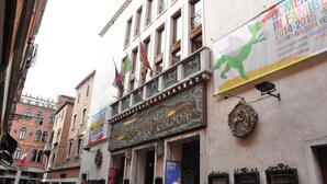 A building with a theater sign and multiple flags. - San Marco Design Suites (Venice)