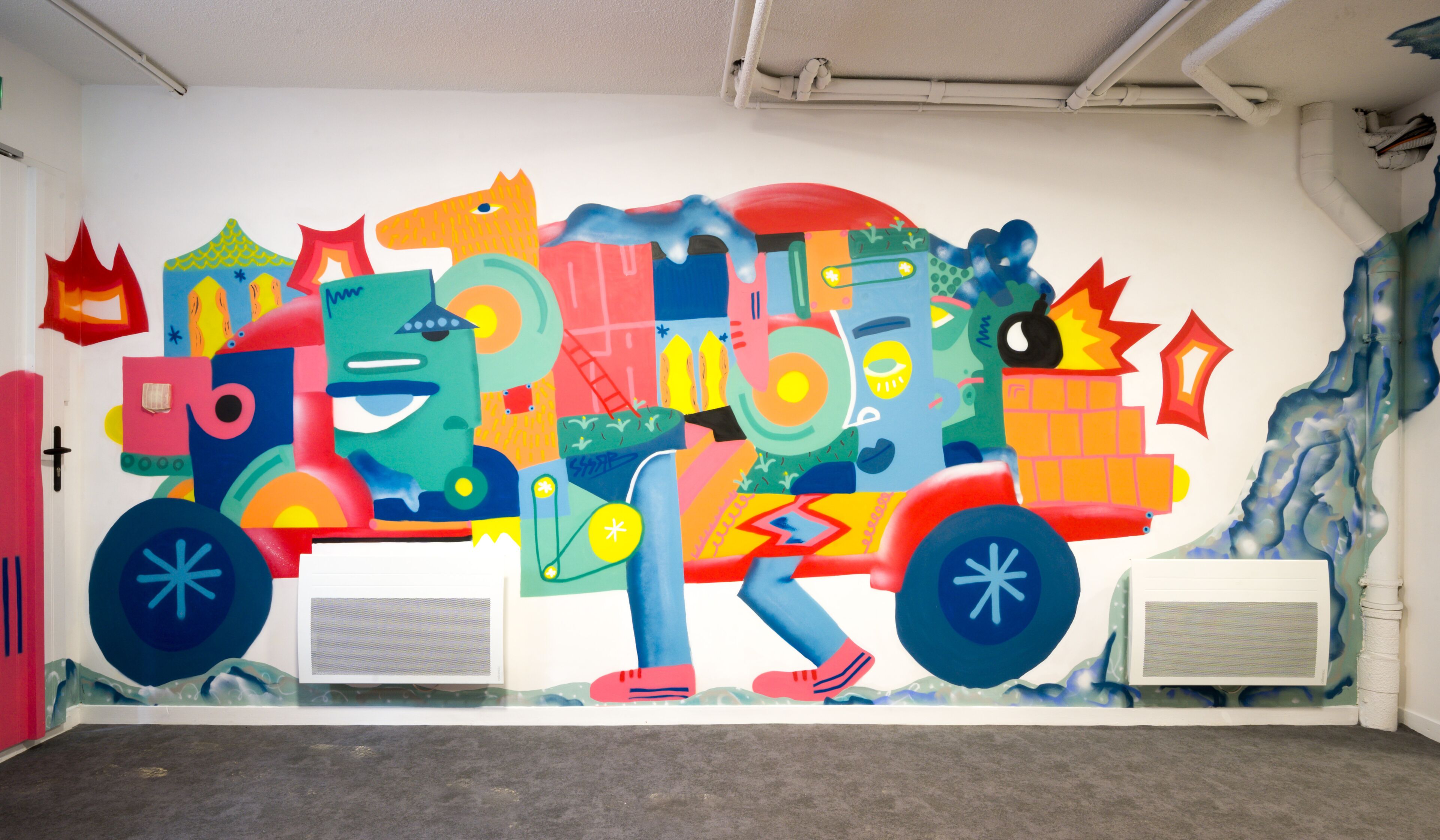 A colorful mural on a wall featuring abstract shapes and figures.