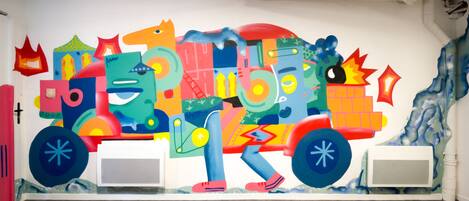 A colorful mural on a wall featuring abstract shapes and figures.