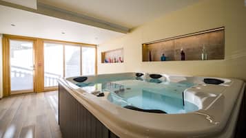 Relax in a spacious bathroom with a hot tub and sliding glass door leading to a balcony.