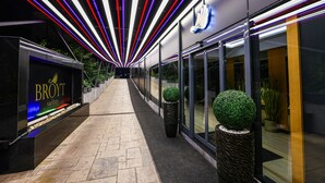 A modern hotel corridor with a neon-lit ceiling, a sign for 'Broytt suites', and potted plants along the walkway. - Broyt Hotel (Istanbul)