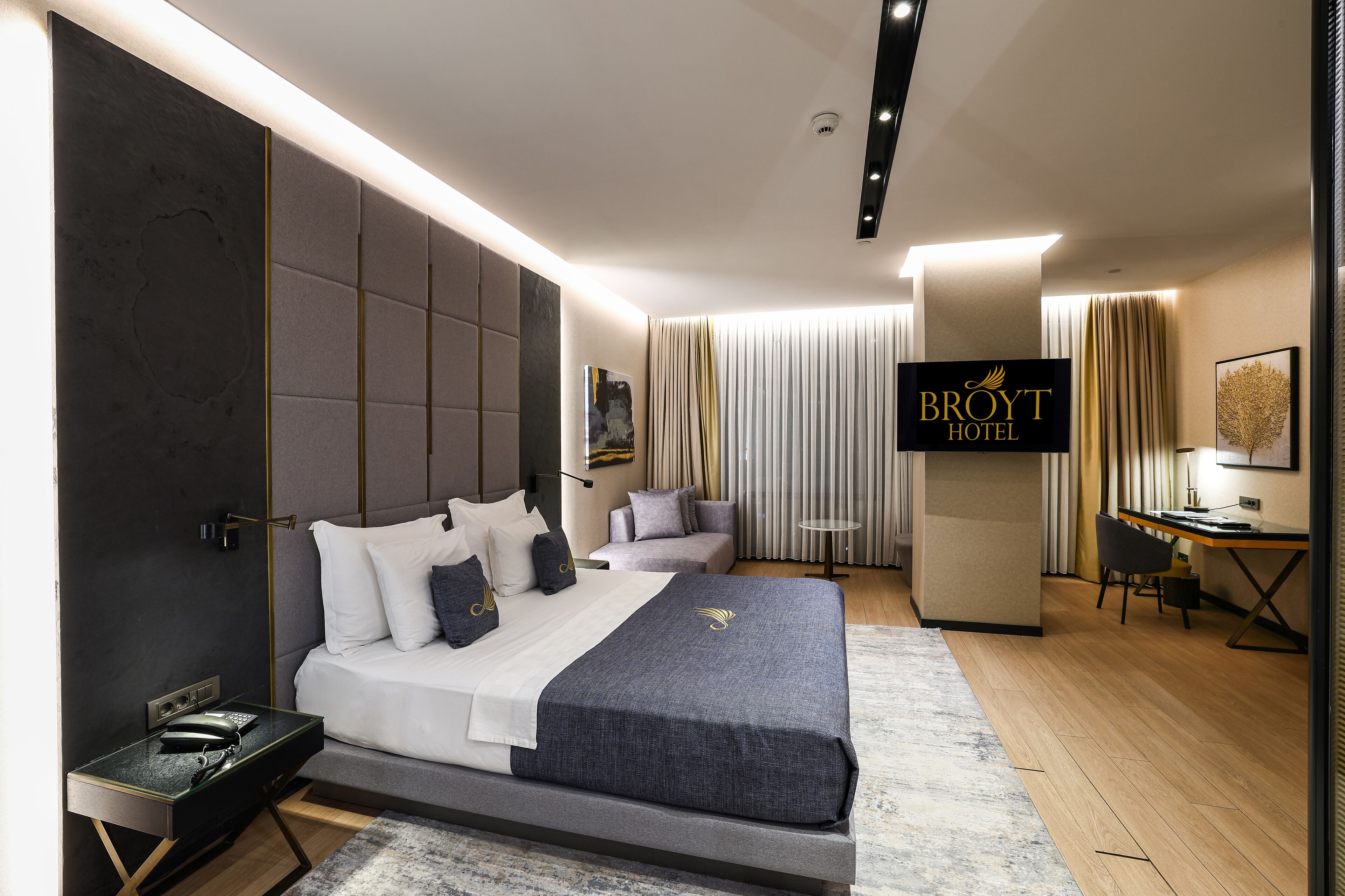 Ein modernes Hotelzimmer mit einem großen Bett, einem Schreibtisch und einem Stuhl.