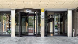 Ein Hotel Eingang mit einer Drehtür, Glastüren und einem gefliesten Boden.