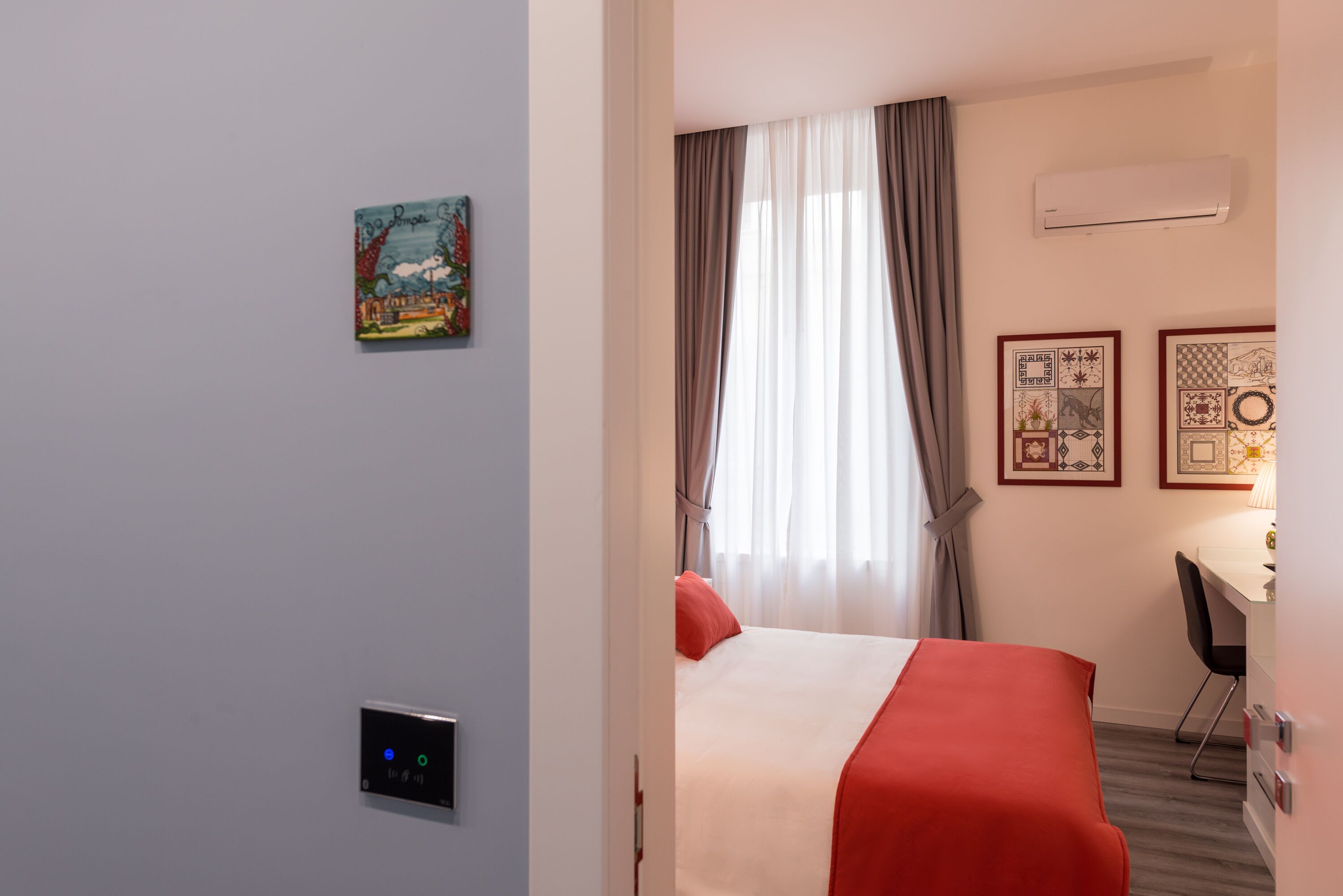 Een hotelkamer met een bed, een bureau en een airconditioner.