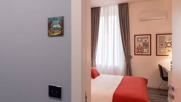 Een hotelkamer met een bed, een bureau en een airconditioner.