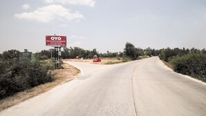 Señal de camino para el resort Kanum Kanoon con un coche rojo estacionado cerca.