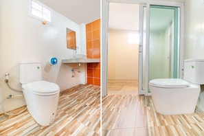 A bathroom with a toilet, sink, and shower area.