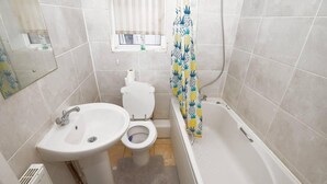 Kylpyhuone, jossa on pesuallas, wc ja kylpyamme.
