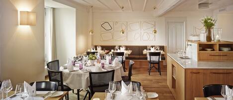 Un restaurante con varias mesas dispuestas para comer, suelo de madera y un diseño de interiores moderno.