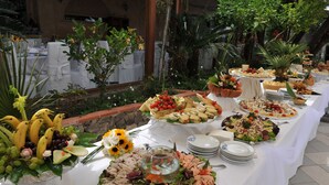 A buffet table with various food items and a glass bowl with goldfish. - L'Incanto Suites Ischia (Casamicciola Terme)