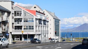 Un edificio de varios pisos con techo rojo y escaparate visible.