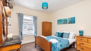 A bedroom with a bed, wooden wardrobe, and a desk with a mirror. - Cosy Home 5 Minute Walk to Monkbar and Bar Walls! (York)