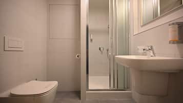 Une salle de bain moderne équipée de toilettes, d’une douche et d’un lavabo.