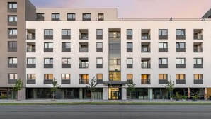 Un hôtel à plusieurs étages, doté d’une façade moderne, de nombreux balcons et d’une entrée au niveau du sol avec une enseigne.