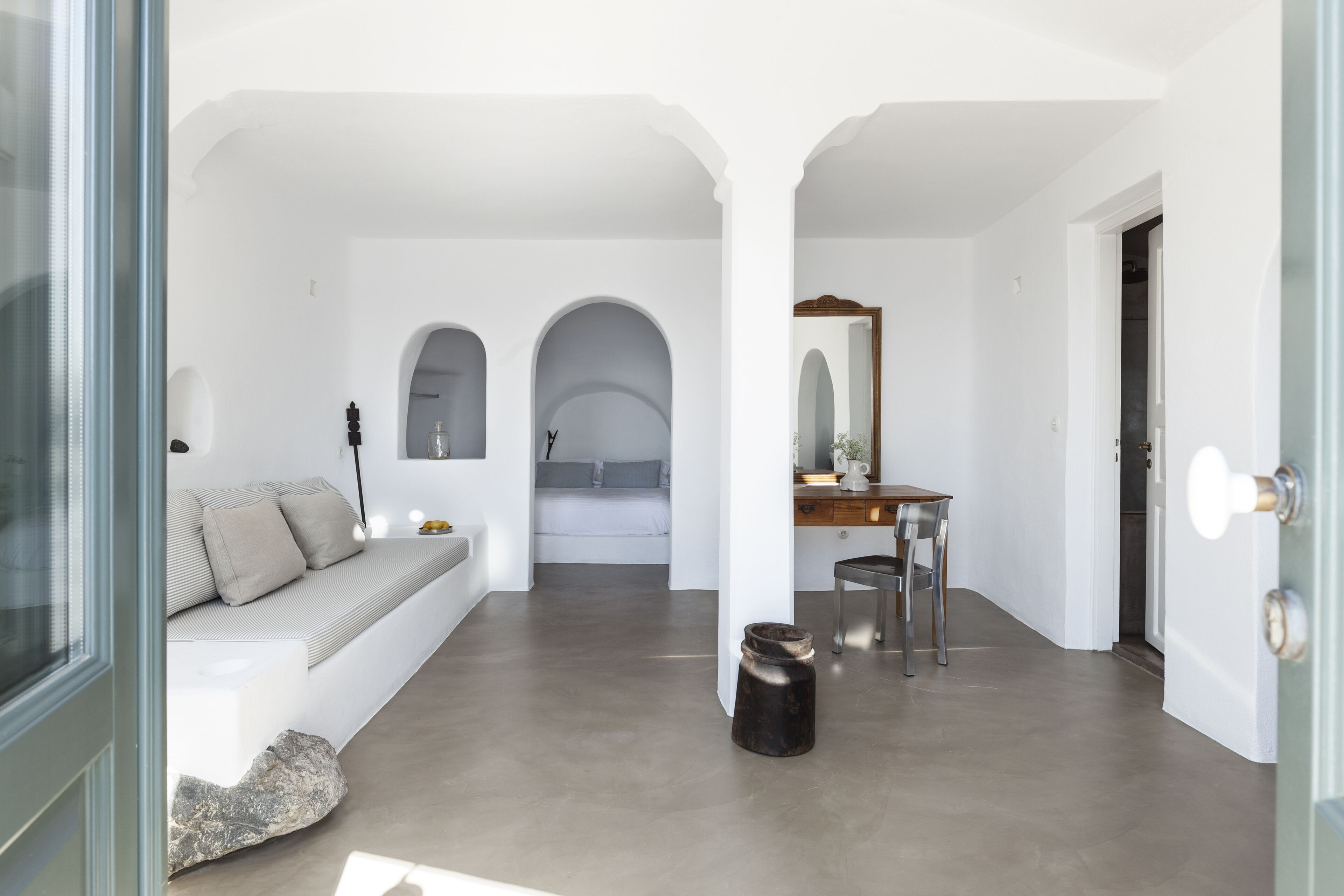 A modern interior with a sofa, a dining table, and a kitchen area.