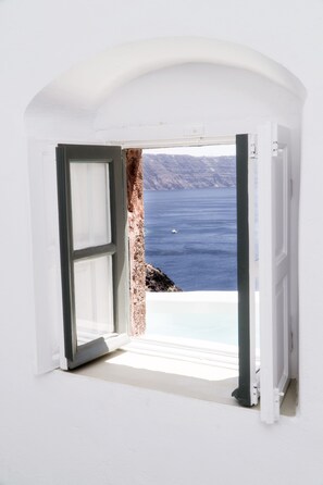 An open doorway leading to a balcony with a view of the sea and rocky landscape. - Spitia Santorini (Santorini)