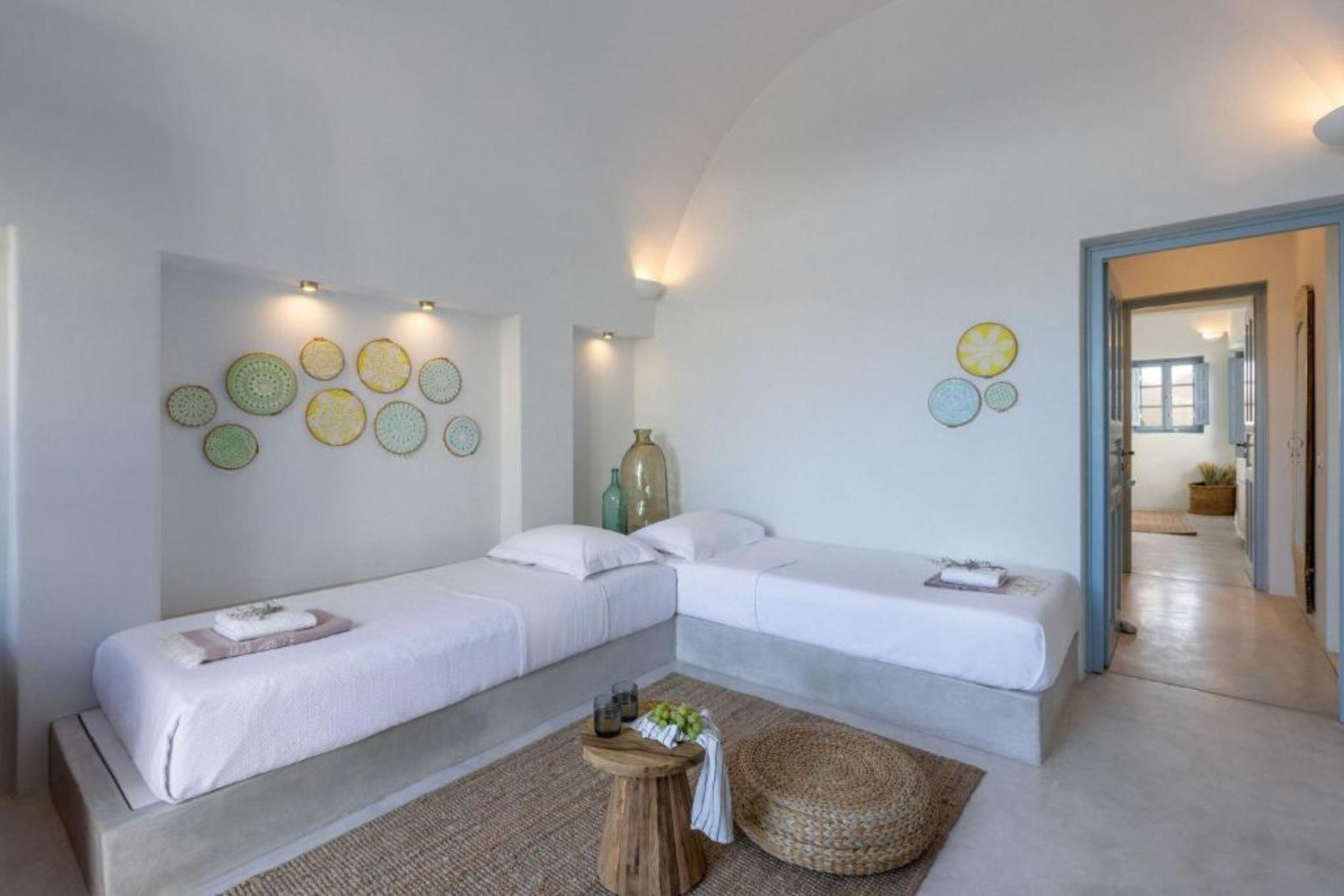 Une chambre avec deux lits, une petite table ronde et des éléments de décoration murale.