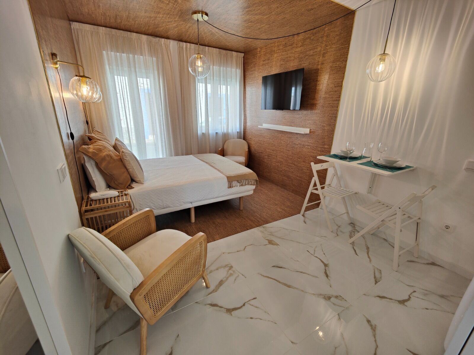 A modern bedroom with a bed, a desk, and a chair.