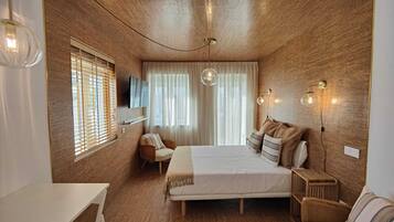 Un dormitorio moderno con una pared de madera, una cama con almohadas, una silla, un televisor y una mesita de noche.