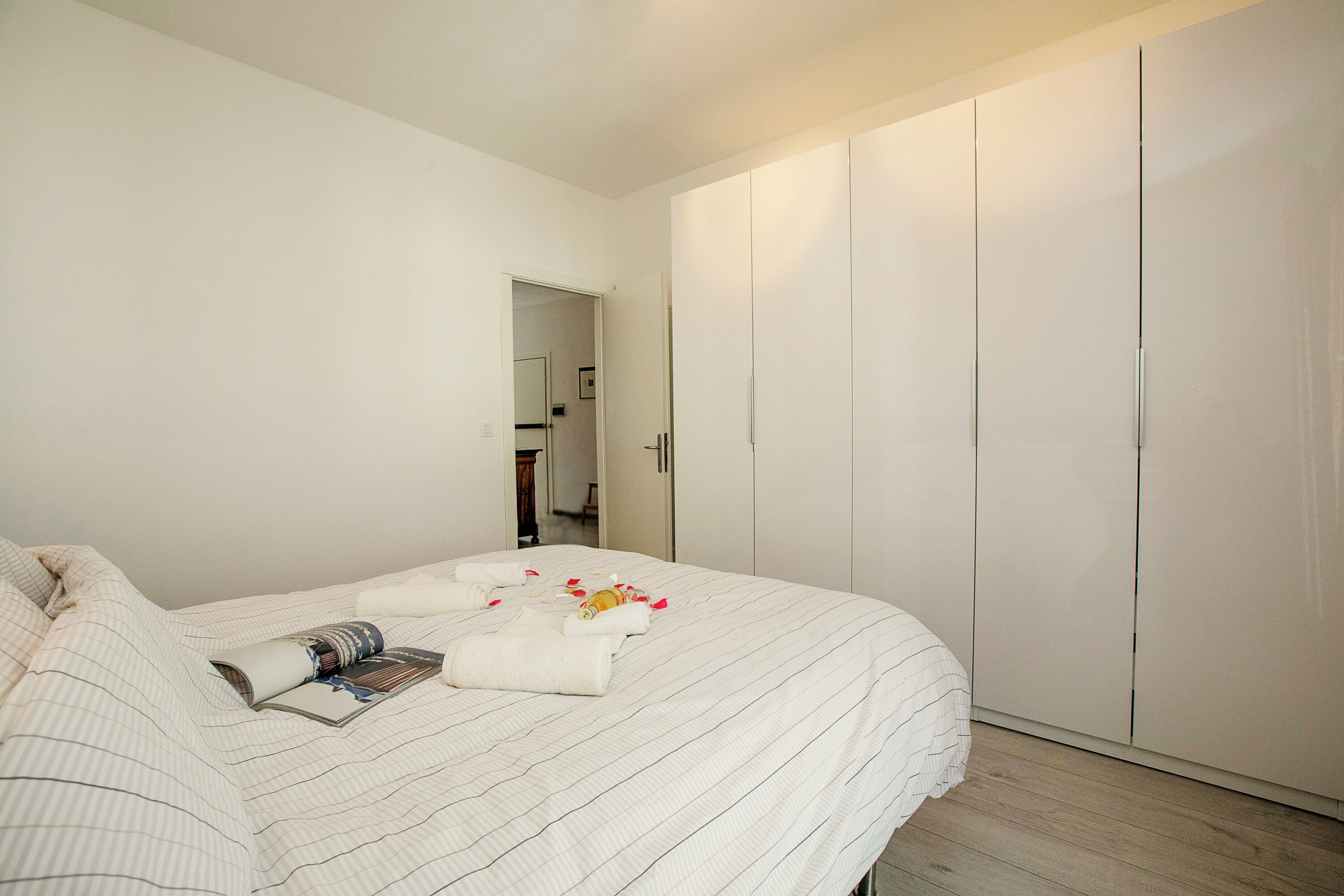 Una camera da letto con un letto, un armadio e una porta che dà su un'altra stanza.