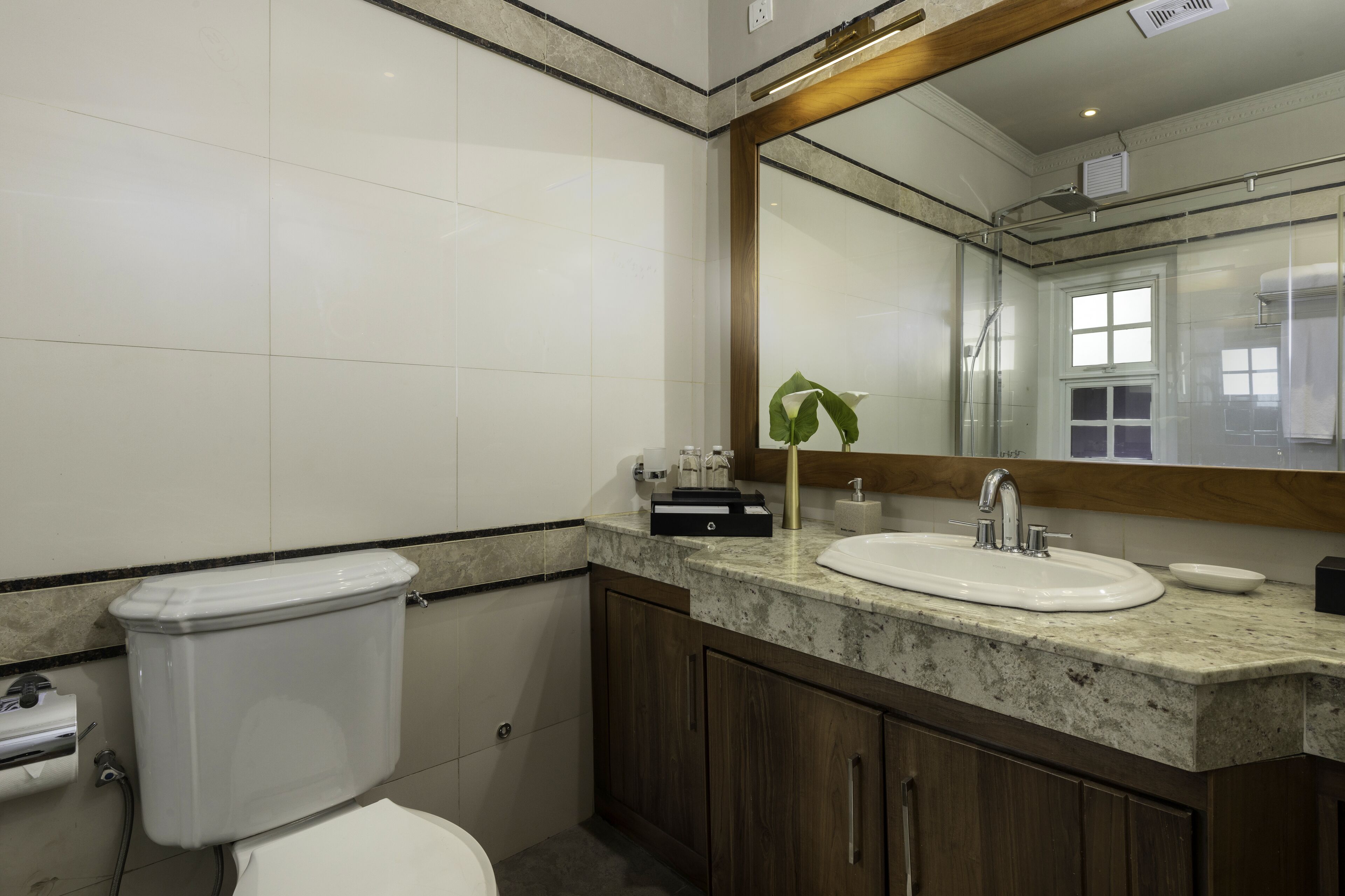 Une salle de bain avec des toilettes, un lavabo et un miroir.