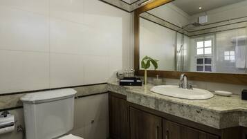 Une salle de bain avec des toilettes, un lavabo et un miroir.