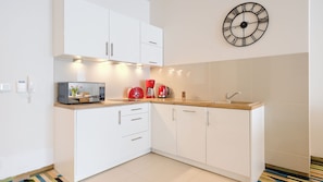 Apartamento (D 112) | Cozinha privada | Geladeira, cooktop, talheres/pratos/utensílios de cozinha