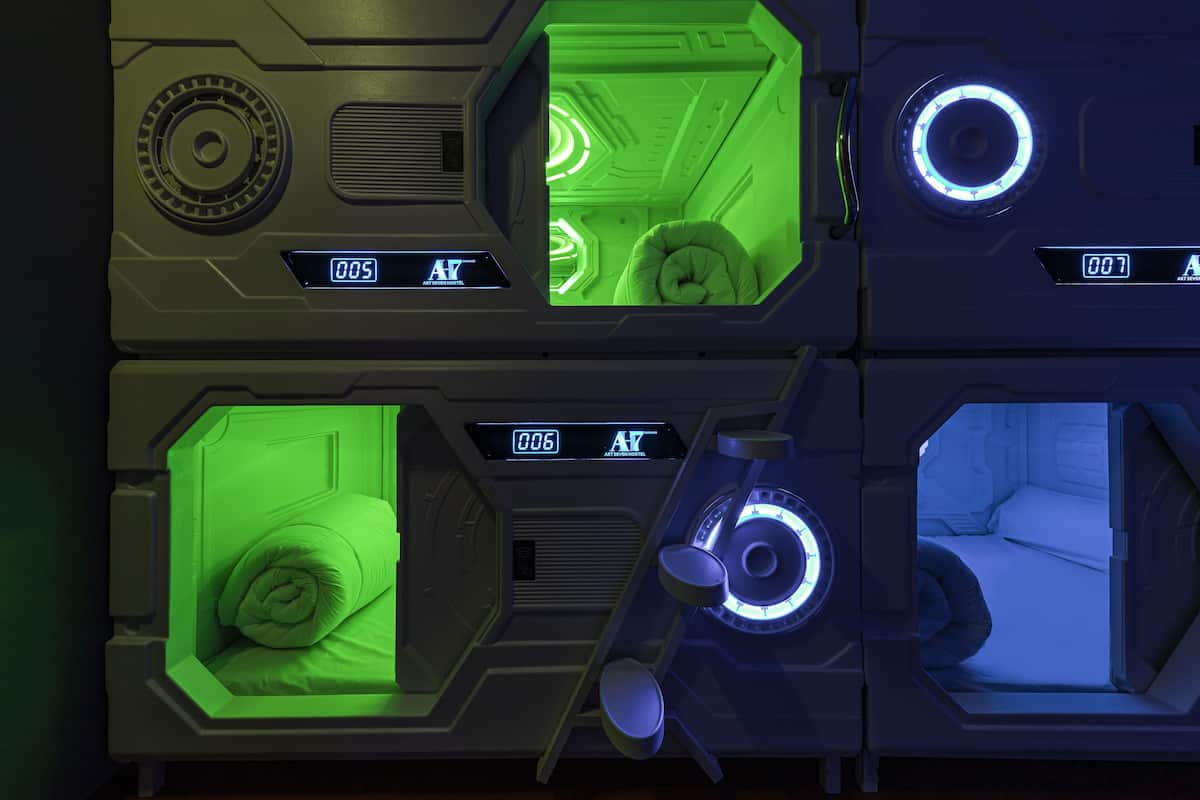 Una habitación futurista con ventanas hexagonales, iluminación verde y pantallas digitales.