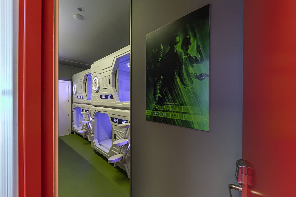 Una habitación con piso verde, una puerta roja y un cartel en la pared.