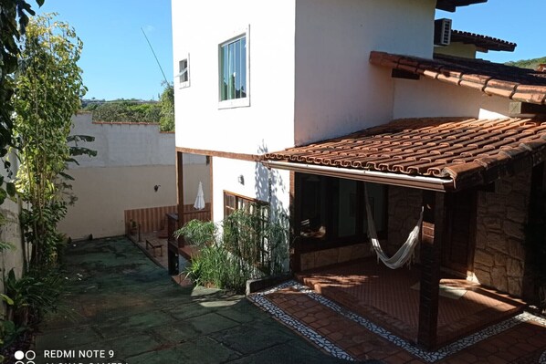A courtyard with a tiled patio, a hammock, and a small seating area.