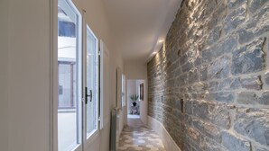 A hallway with a stone wall, a radiator, and a hexagonal patterned floor.