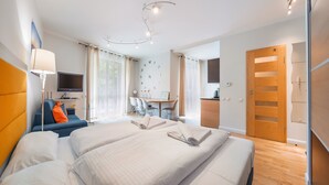 Habitación de hotel con dos camas, un escritorio, televisor y armario.
