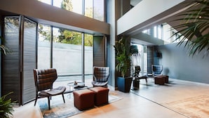A spacious lobby with large windows, modern seating, and a large potted plant. - Avantgarde Urban Şişli (Istanbul)
