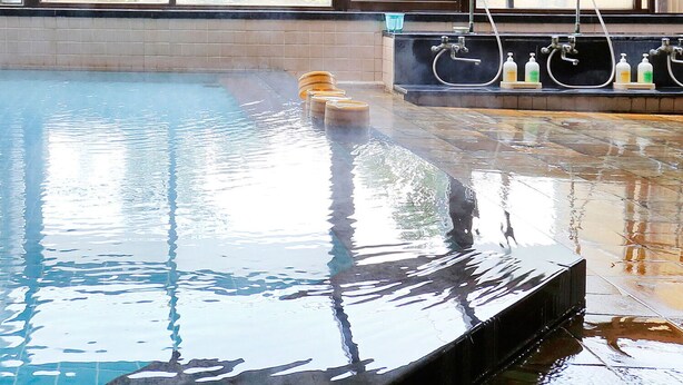 An indoor swimming pool with clear water, a diving board, and a window with a view of greenery. - Daikans (Chikushino)