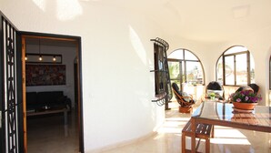 A spacious living area with a glass table, wooden chairs, and a potted plant. - CASA CARLOS - Private Villa Detached with Pool (Cdad. Quesada)