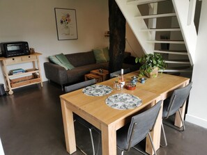 A dining area with a wooden table, two chairs, and a plant. - Erve Het Roolvink (Enschede)