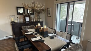 A dining area with a dark wooden table, multiple candles, and a chandelier. - Sun Soaked Views, Pool, Spa; and Spectacular Mountain Views (Lincoln)