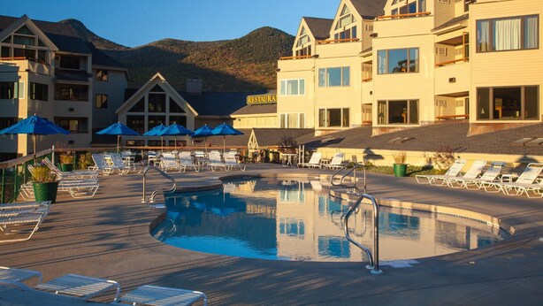 A hotel with a pool area, lounge chairs, and a mountain backdrop. - Sun Soaked Views, Pool, Spa; and Spectacular Mountain Views (Lincoln)