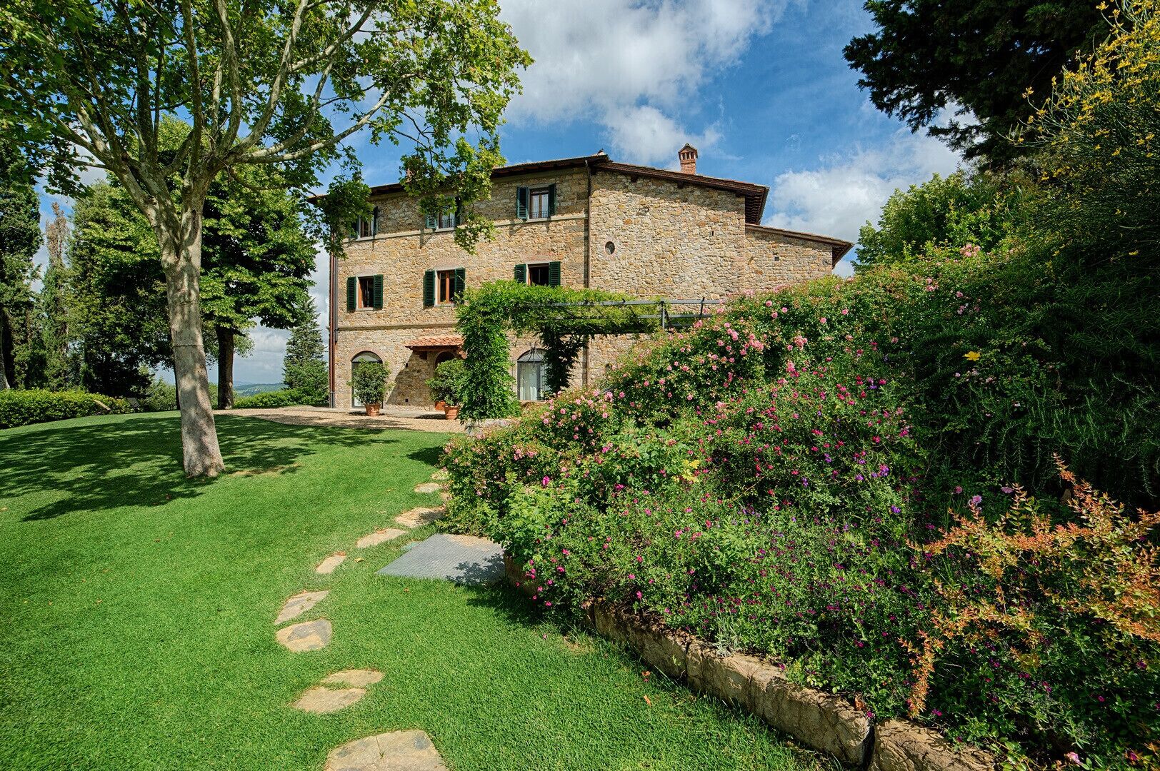 A stone building with a garden pathway leading to the entrance.