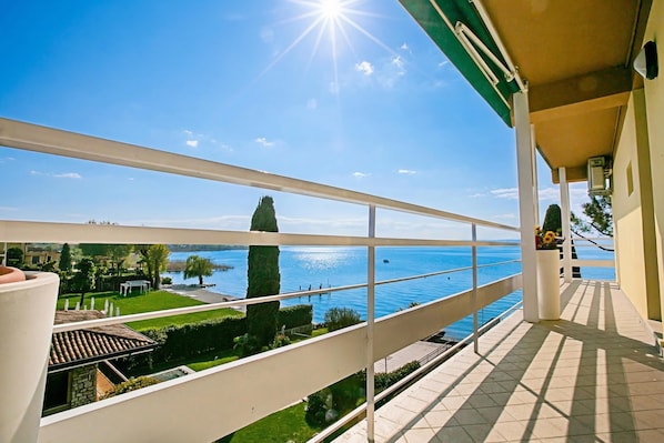A balcony with a clear view of a lake and a distant shoreline. - Casa Bel Tramonto (Sirmione)