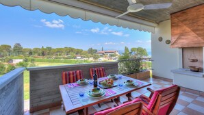 A balcony with a table set for dining, a ceiling fan, and a view of the landscape. - Residenza Verde (Desenzano del Garda)
