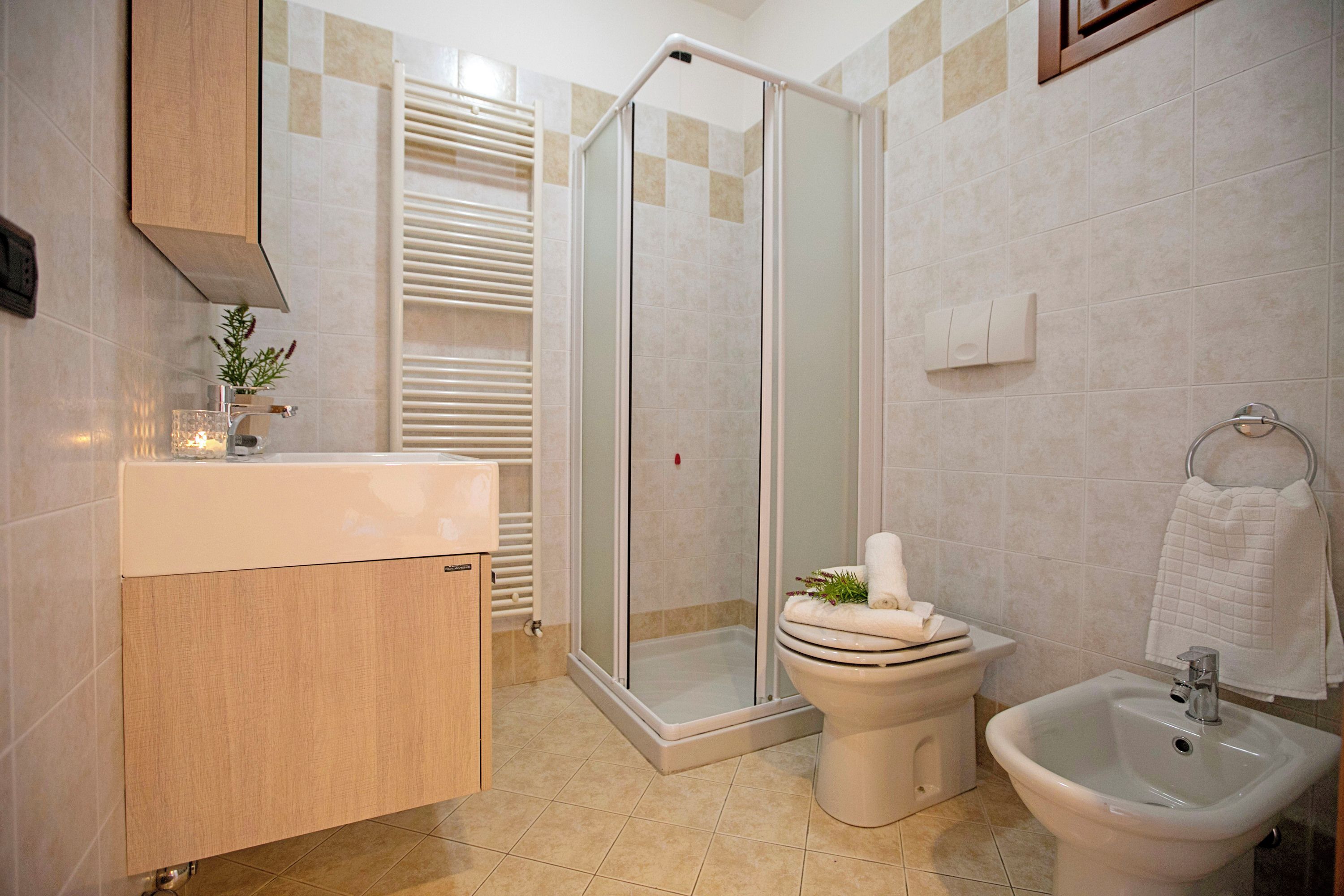 Un bagno con doccia, WC, bidet e lavandino.
