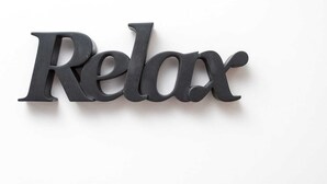 Un letrero en la pared con la palabra 'Relax' en una tipografía estilizada.