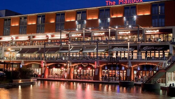 Et hotel ved vandet med flere spisemuligheder, heriblandt en markant restaurant ved navn 'The Mailbox'.