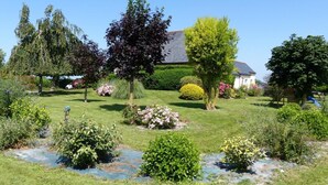 Un jardin bien entretenu, agrémenté de diverses plantes et d’un petit étang.